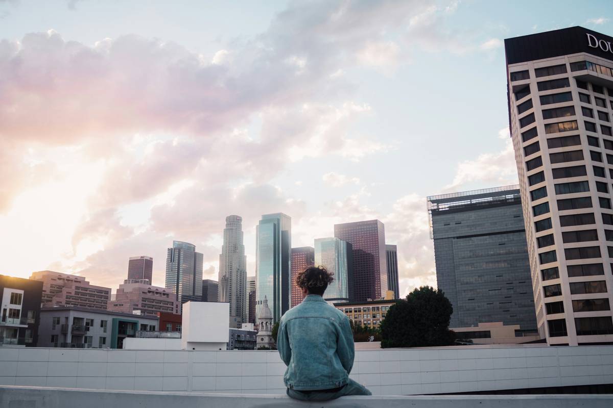 Woman practicing urban mindfulness buddhify zen while sitting on a park bench in a city